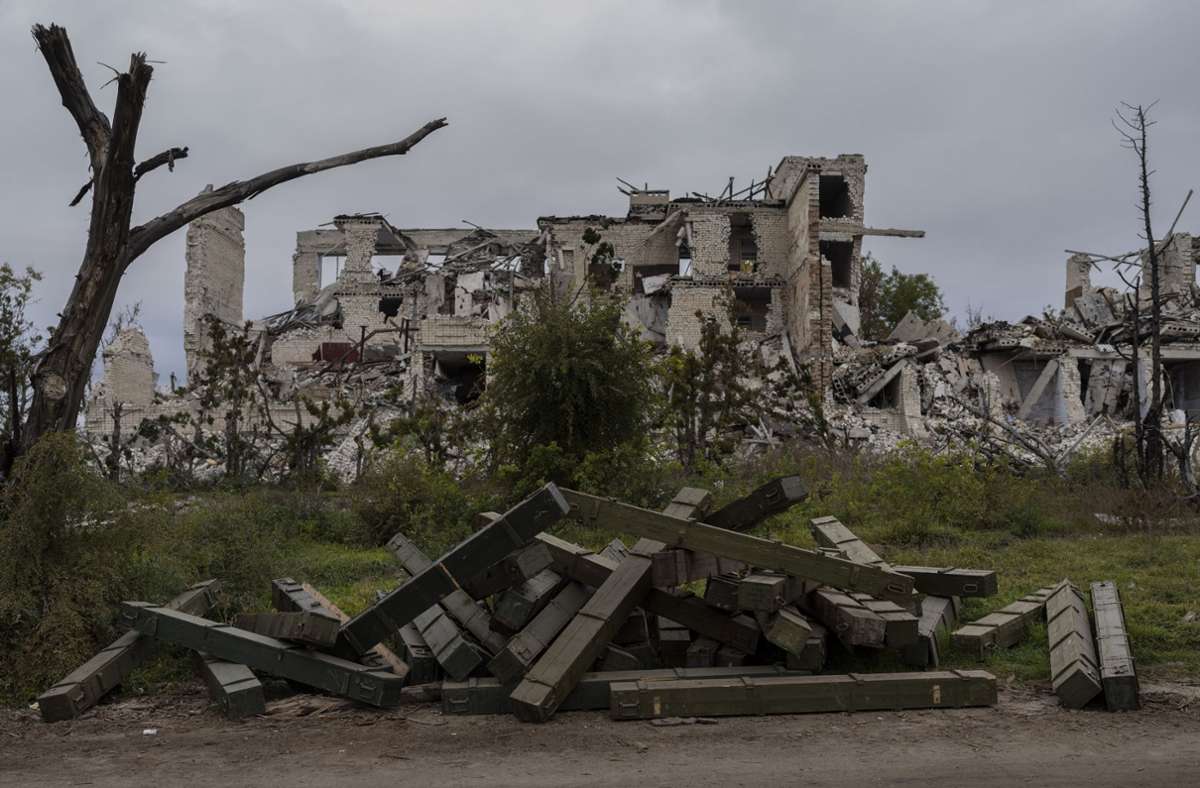 Munitionskisten liegen vor einer zerstörten Schule in einem kürzlich befreiten Dorf am Rande von Cherson. Foto: dpa/Bernat Armangue