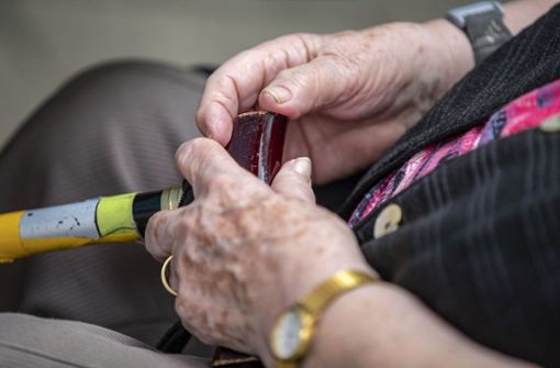 Eine Seniorin hält ihren Gehstock in den Händen - Symbolfoto Foto: dpa