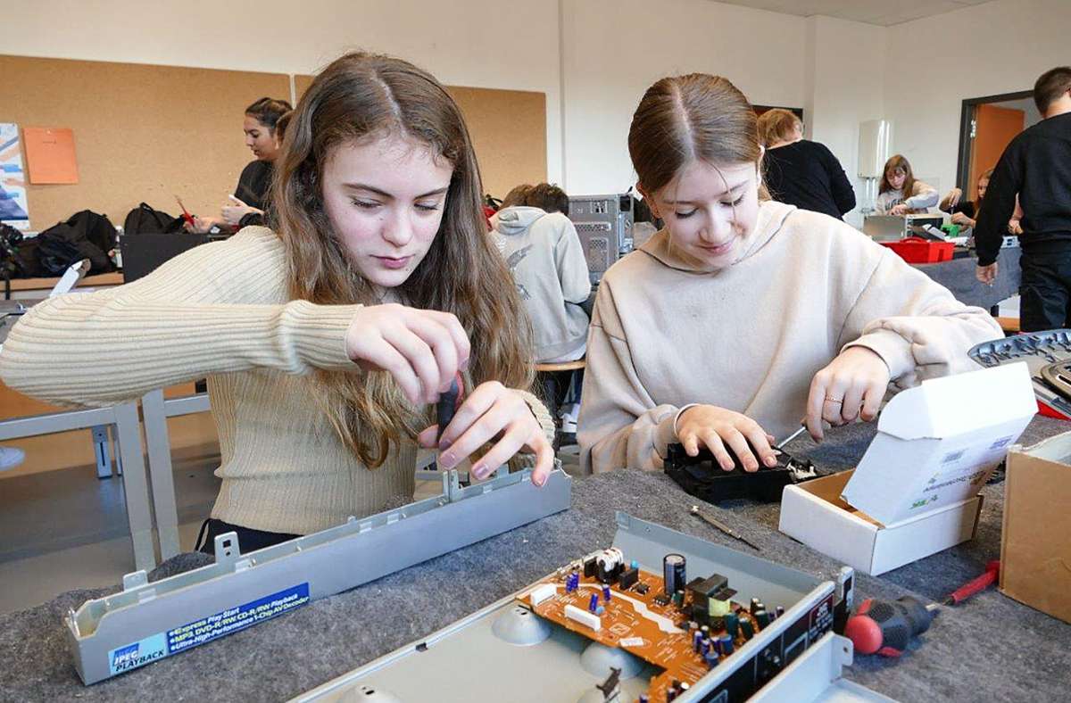 Die beiden Schülerinnen  zerlegen im Zuge des Projekts „Schraubertonne“ des Abfallzweckverbands Elektrogeräte. Foto: Sandra Hüttner