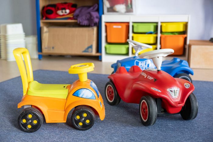 Spielzeugautos stehen in einer Kita.