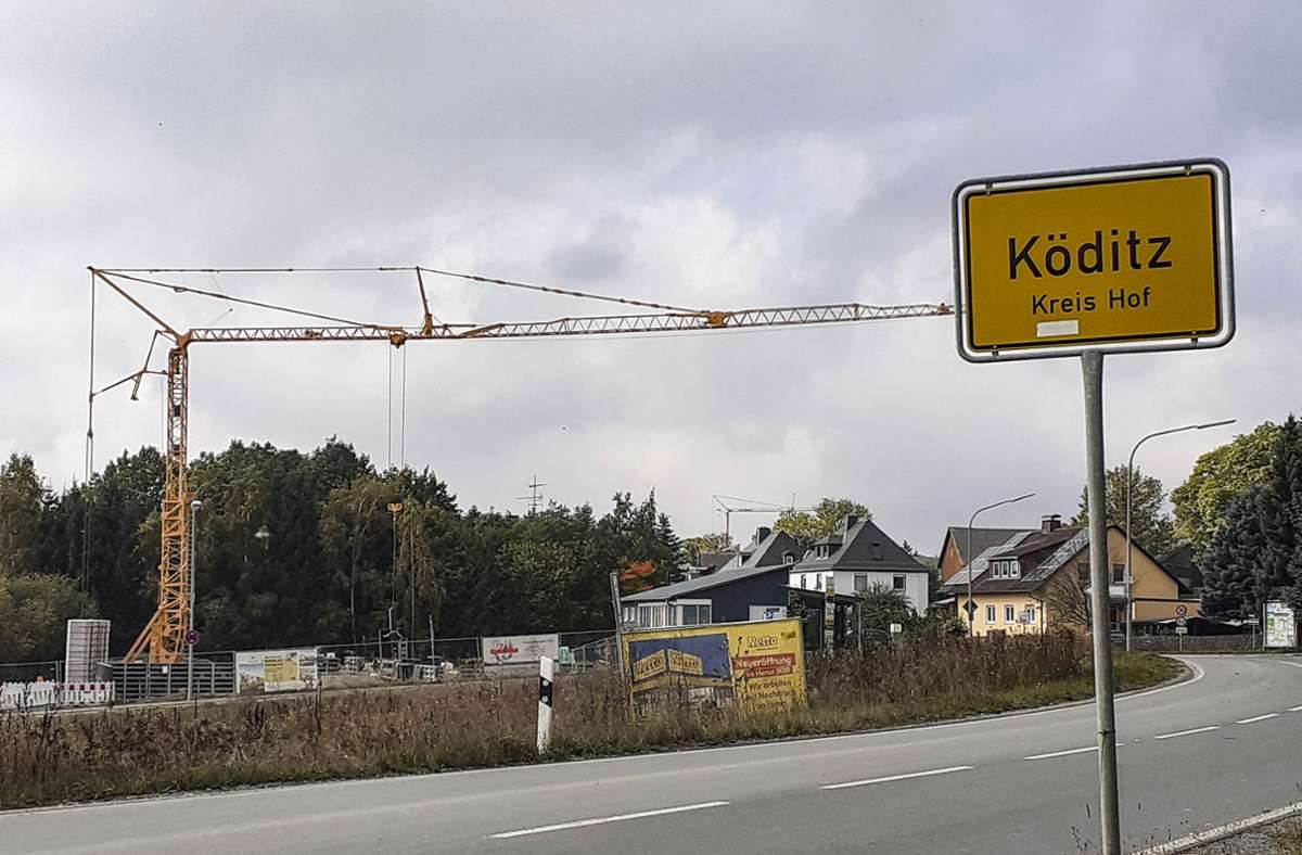 Zwei große Kräne markieren die Baustellen der Wohngebäude in Köditz; ein Plakat weist auf den Netto-Neubau hin.
