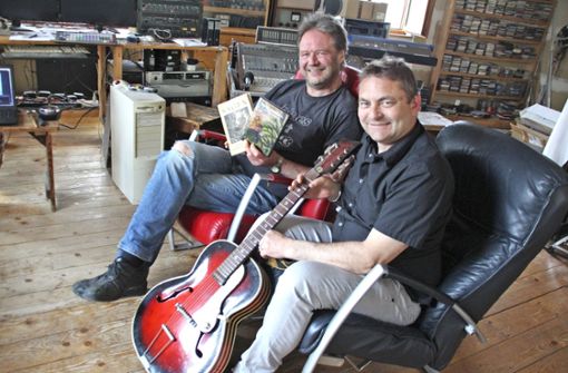 Harry Tröger (hinten) und Ralf Wunschelmeier mit CD und Sagenbuch in Trögers Münchberger Tonstudio. Foto: /Schwappacher