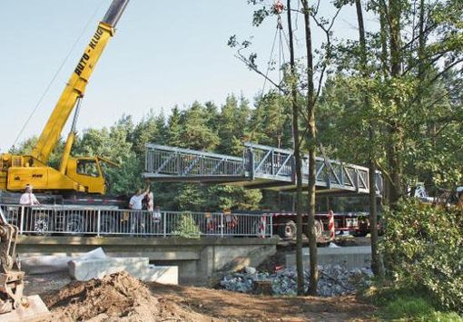 Mit einem Autokran wurde am frühen Freitagvormittag die Brücke für den neuen Radweg bei Dürrewiesen eingesetzt. 	Foto: Gisela König Quelle: Unbekannt