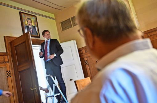 Unter den Augen von Karl-Willi Beck brachte der Wunsiedler Bürgermeister Nicolas Lahovnik das Porträt seines Amtsvorgängers an der Wand an. Foto:  