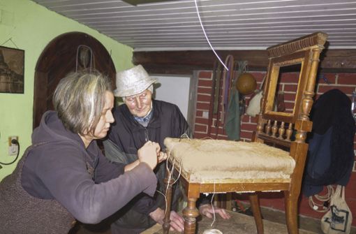 Friederike Seedorf und der fast 88-jährige Gerhard Hopperdietzel restaurieren einen gepolsterten Stuhl, der deutlich über 100 Jahre alt ist – zu sehen demnächst im Bayerischen Fernsehen. Foto: /Metzner