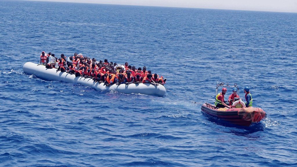 Bei Wind und Wellen halten die Seenotretter, darunter Hannes Neubauer (vorne links), Flüchtlingsboote zunächst auf Position, damit sie nicht in libysche Gewässer abtreiben. Nach und nach bringen die Helfer dann jeweils sechs bis acht Schiffbrüchige mit ihrem Schlauchboot auf die große "Lifeline".