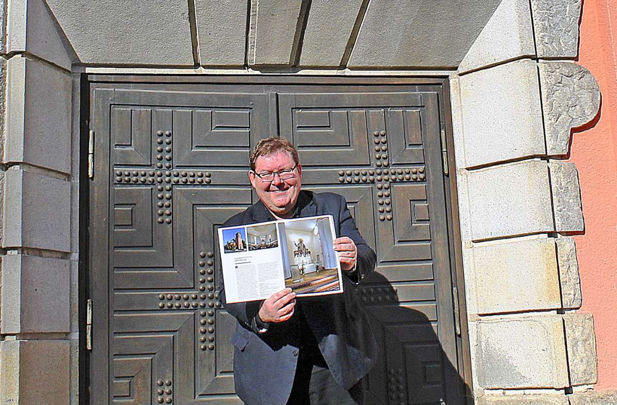Pfarrer  Jürgen Henkel zeigt die Seiten mit Erkersreuth im Bildband „Denkmal Hochfranken. Vorbildliche Sanierungen.“. Foto: pr.