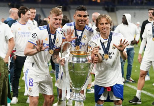Toni Kroos (vorne, l-r), Carlos Casemiro und Luka Modric von Real Madrid jubeln mit der Trophäe nach dem Champions-League-Sieg. Foto: picture alliance/dpa/PA Wire | Nick Potts