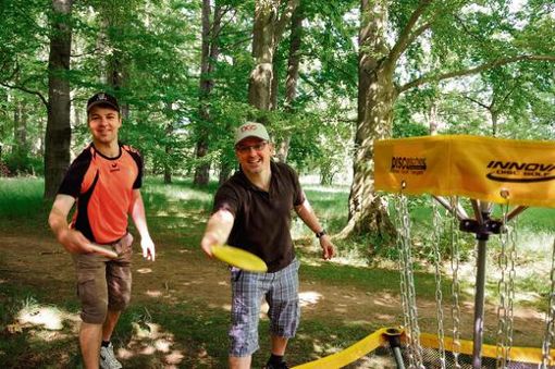 Mit Frisbee und Fang-Korb: Marian Ludwig (links) und Jan-Dirk Müller-Esdohr treffen sich regelmäßig zum Discgolfen. Foto: cp
