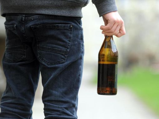 Ein Mann hält eine geöffnete Bierflasche in der Hand - Symbolfoto Foto: Tobias Hase/dpa