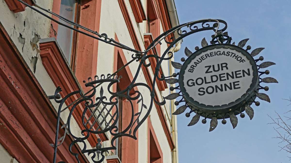 Das Schild Brauereigasthof Zur goldenen Sonne in Lichtenberg im Landkreis Hof an einer Hausfassade.