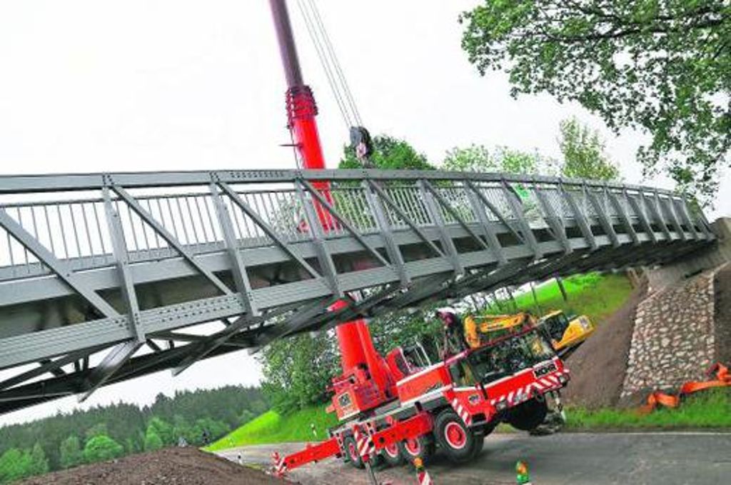 Ein Kran hievte die 9,4 Tonnen schwere Aluminiumbrücke am gestrigen Vormittag auf die Pfeiler.