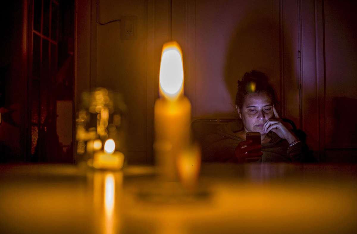 Dann eben Beleuchtung mit Kerzenlicht. Auch der Handyakku hält bei einem längerfristigen Blackout nicht ewig. Foto: dpa/Roberto Almeida Aveledo